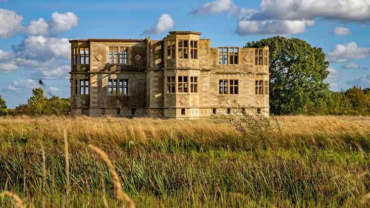 The Garden Lodge surrounded by long grass in the summer.